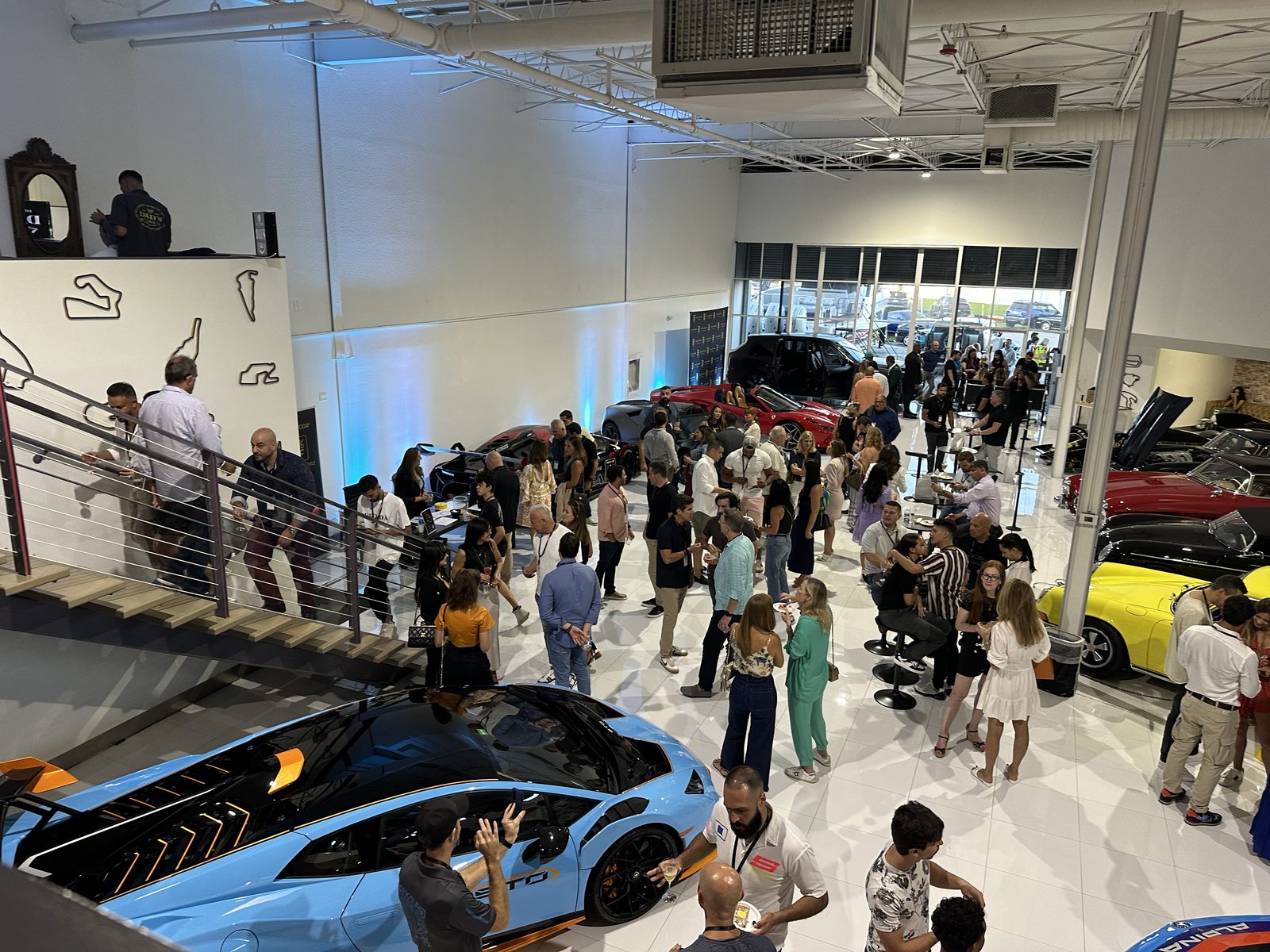 Packed showroom event with guests and supercars on the ANSA floor